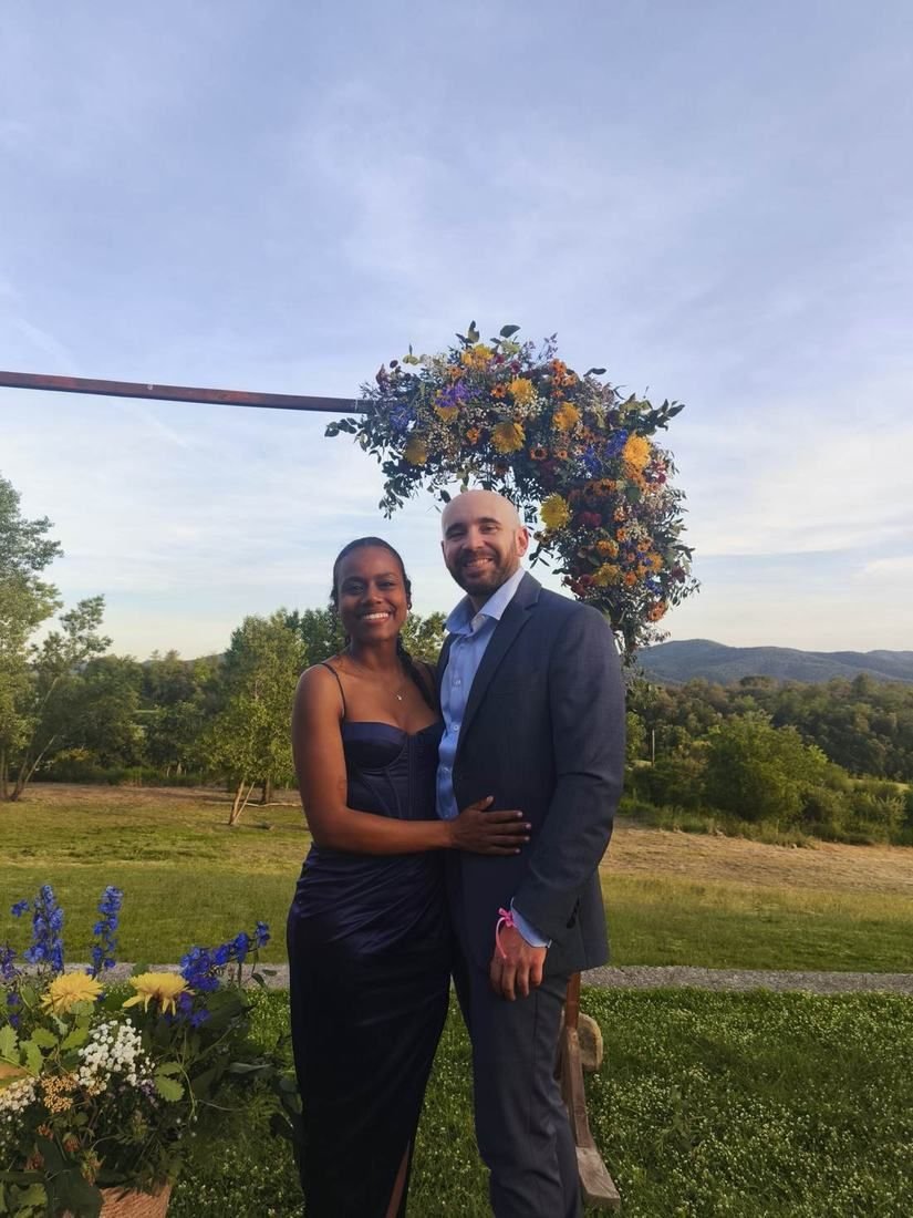 Anton y Lina junto a un arco de flores